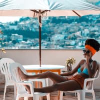 Coronavirus Urlaub Reisen möglich? Frau liegt auf dem Balkon im Bikini