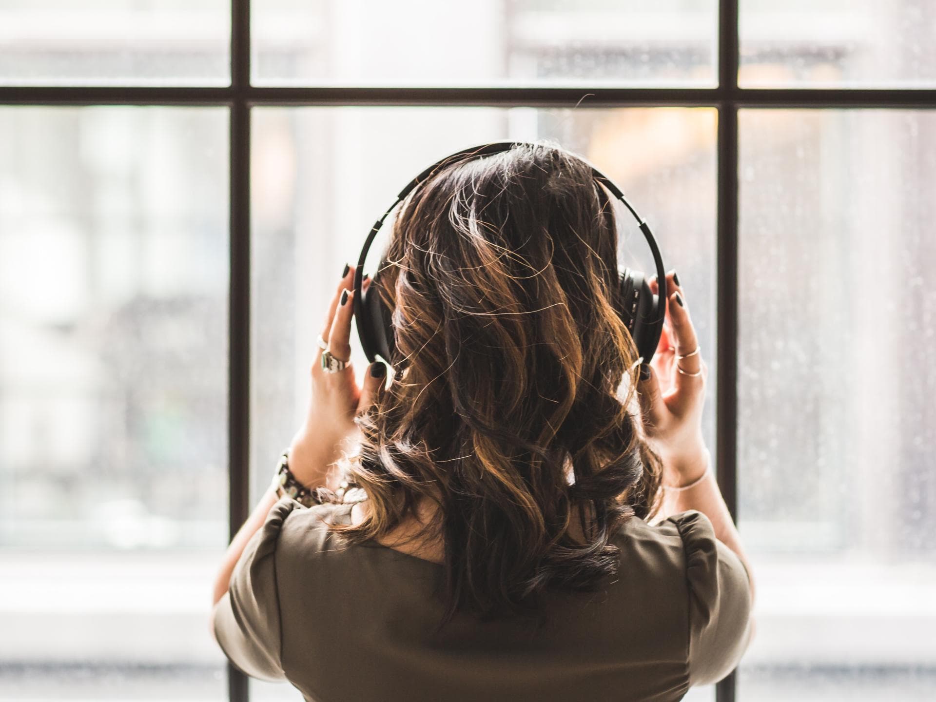Spotify Jahresrückkblick Mädchen mit Kopfhörern vor einem Fenster